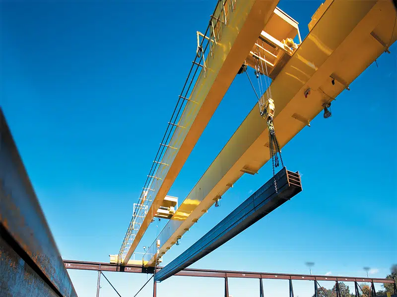 overhead crane with double hoist lifts steel